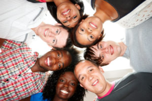 group of multiracial young students huddled together